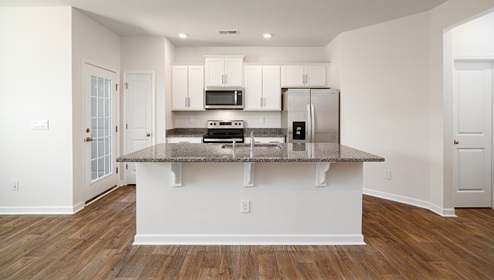 Kitchen and island with white cabinets, subway tile backsplash, and stainless steel appliances
