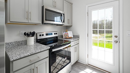 Fergus Crossing Townhomes Newton Model kitchen with white cabinets, and stainless steel appliances