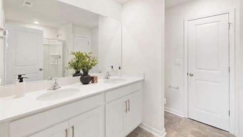 Fergus Crossing Townhomes Model Bathroom with double sinks, white counters and cabinets