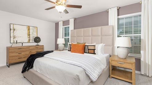 Primary bedroom with carpet and large windows