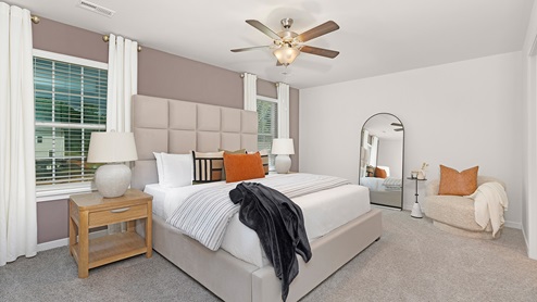 Primary bedroom with carpet and large windows
