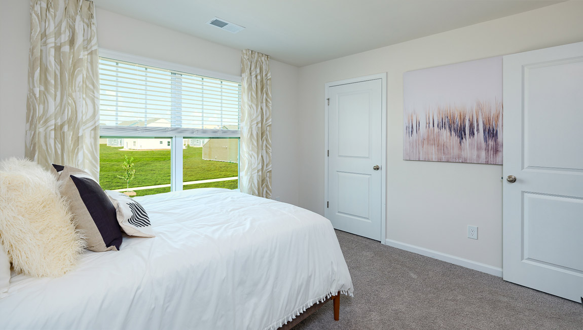 Model carpeted bedroom with small window