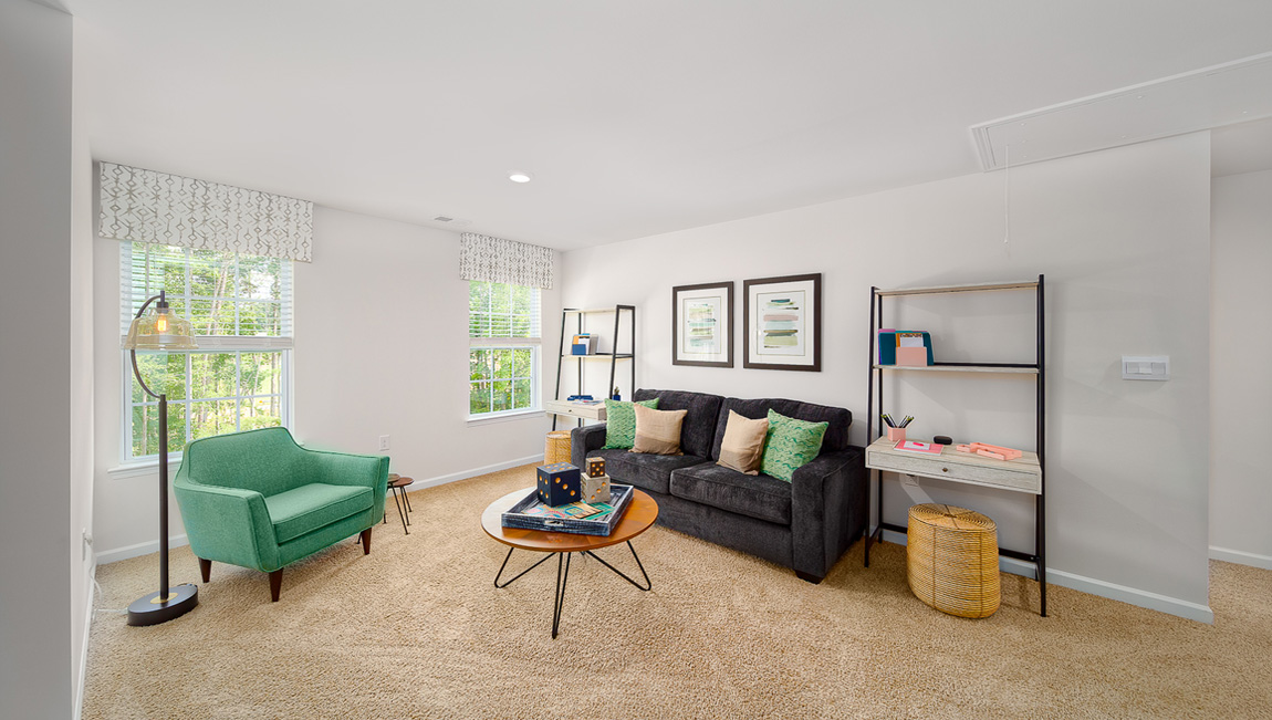 Spacious carpeted upstairs loft space with two large windows