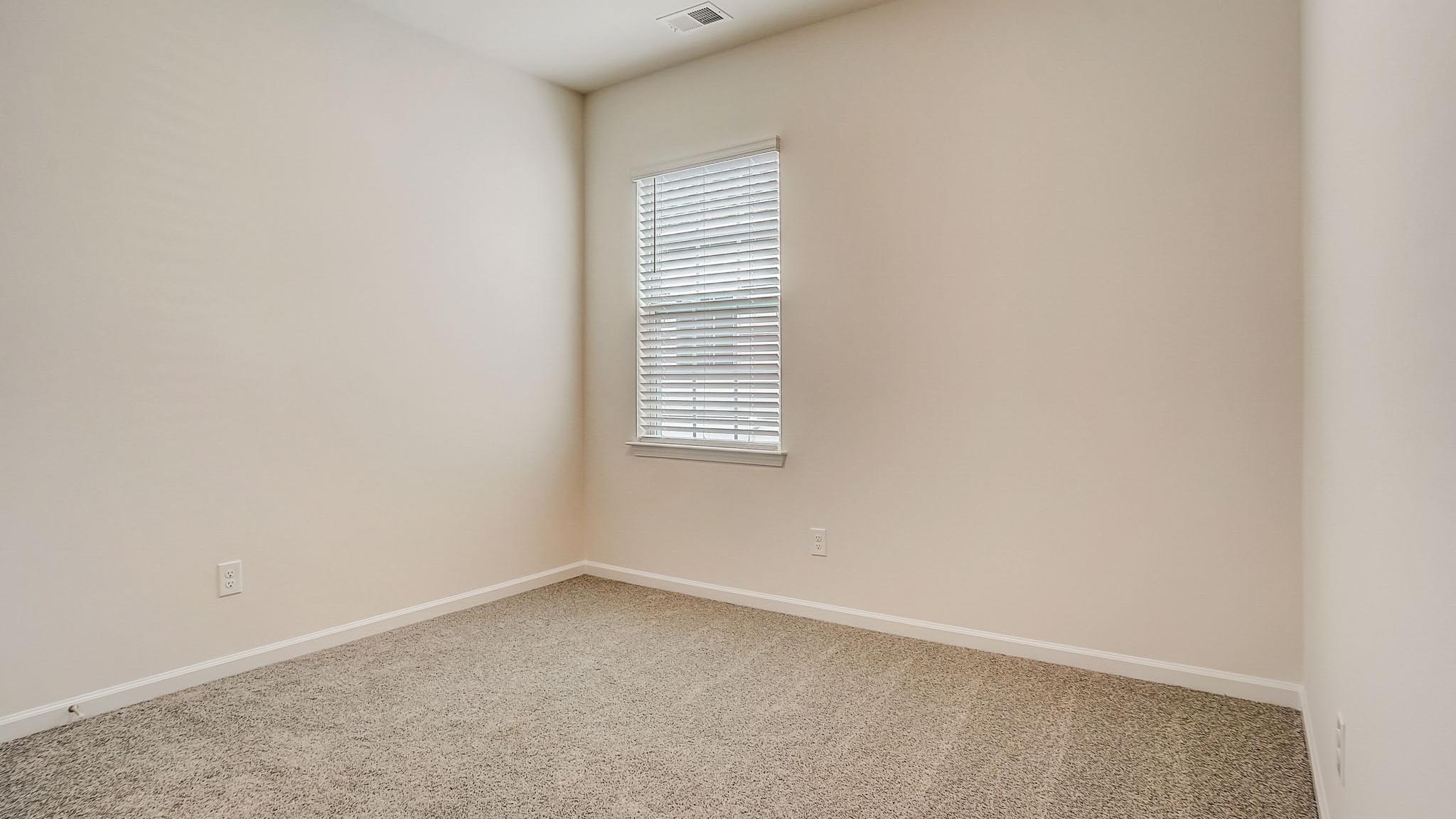 Carpeted bedroom with large window