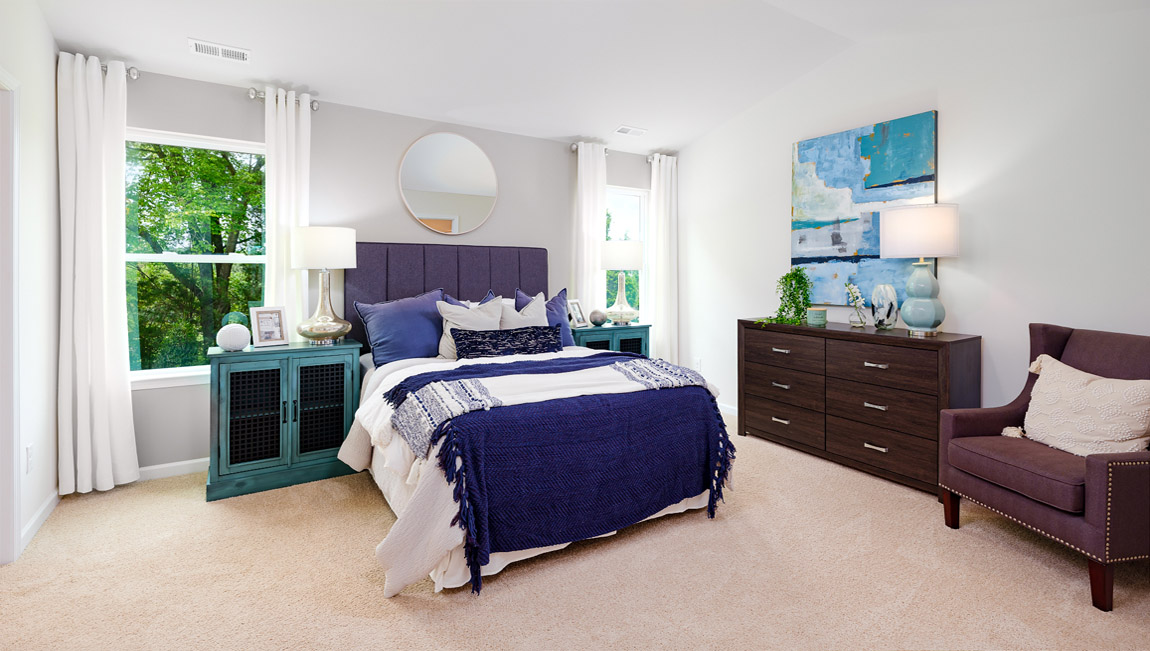 carpeted bedroom with two windows