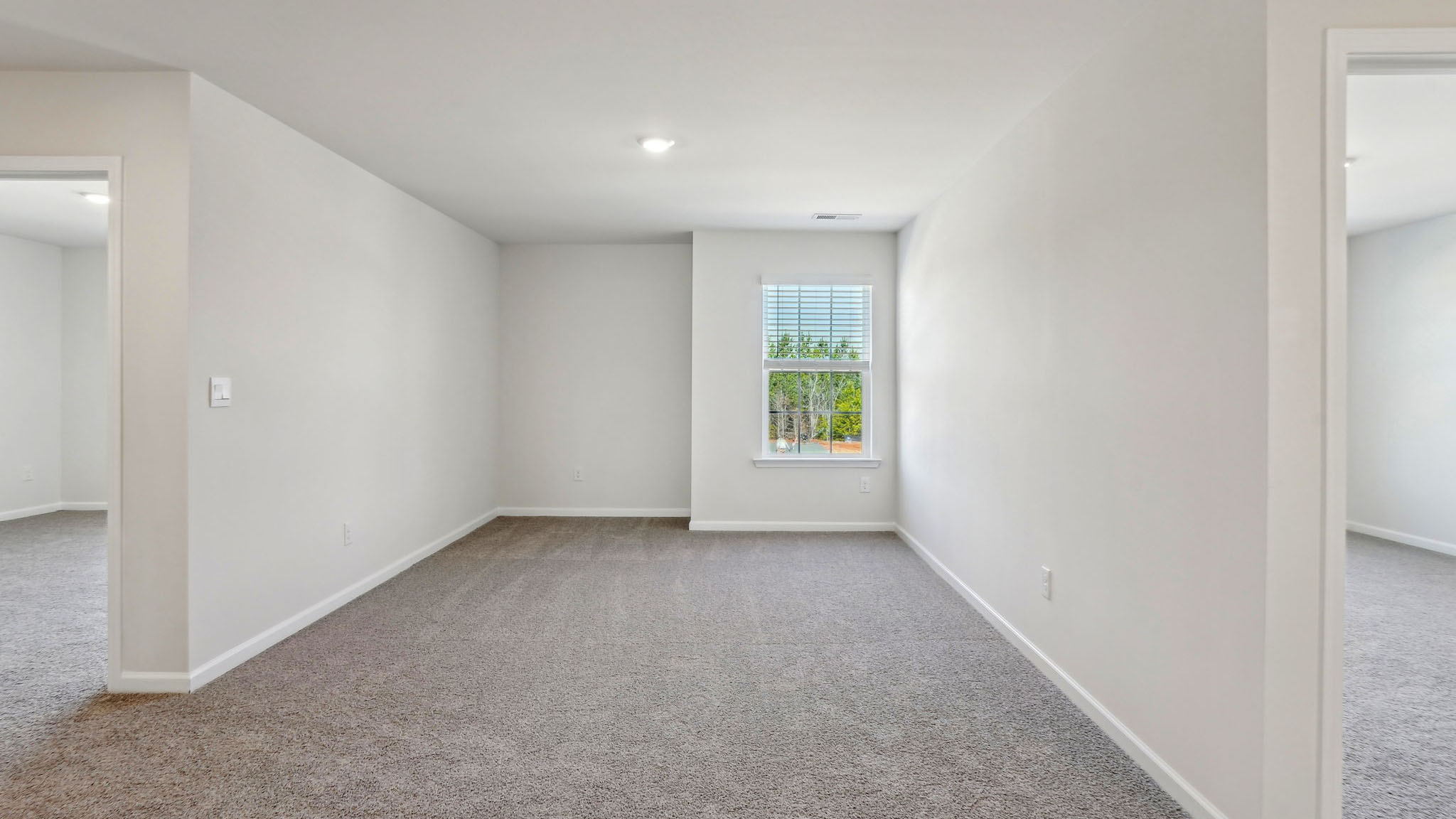 Upstairs carpeted loft with small window