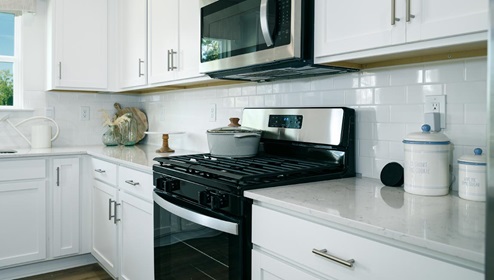 Open kitchen and island with stainless steel appliances