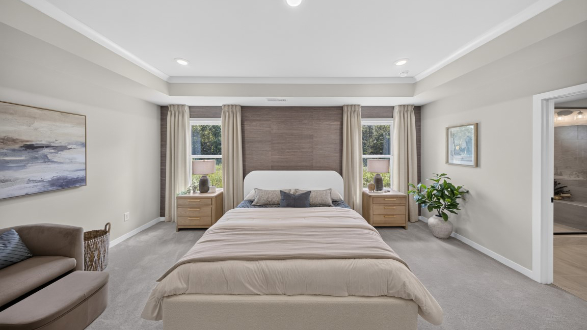 Primary carpeted bedroom with windows