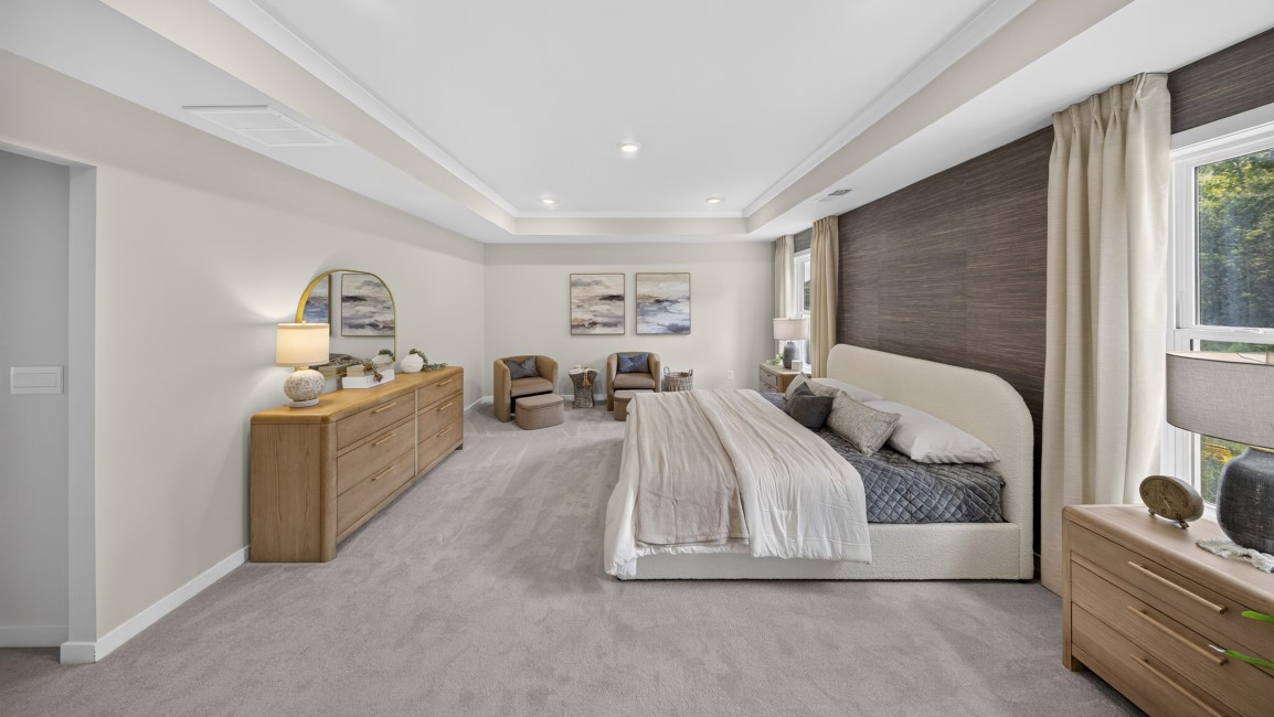 Primary carpeted bedroom with windows