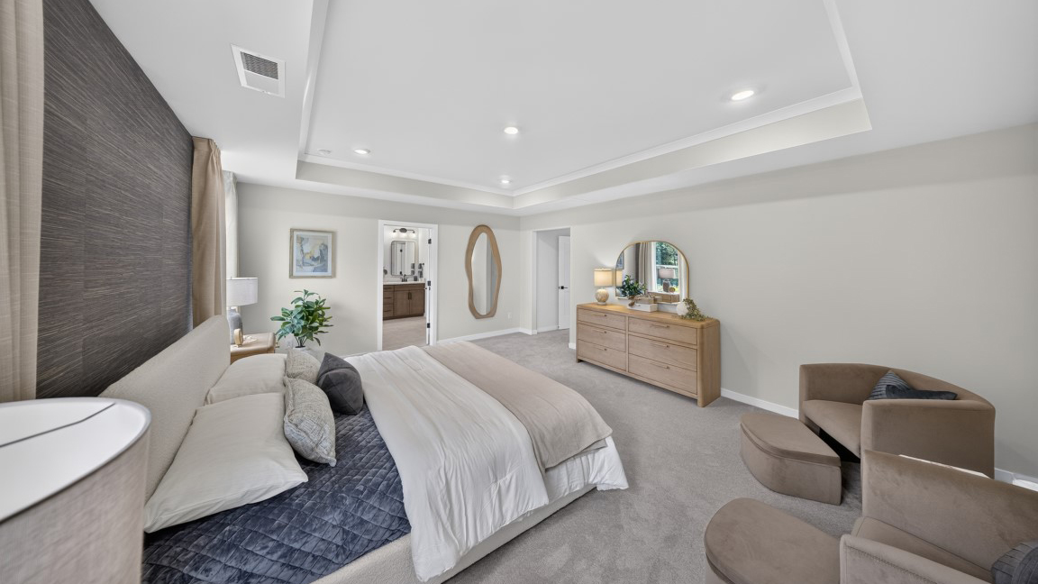 Primary carpeted bedroom with windows