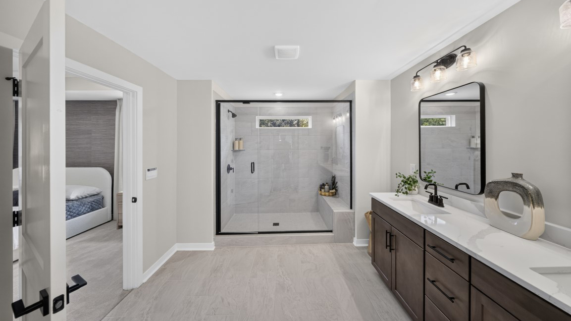 Primary bathroom with standing glass shower and double sinks
