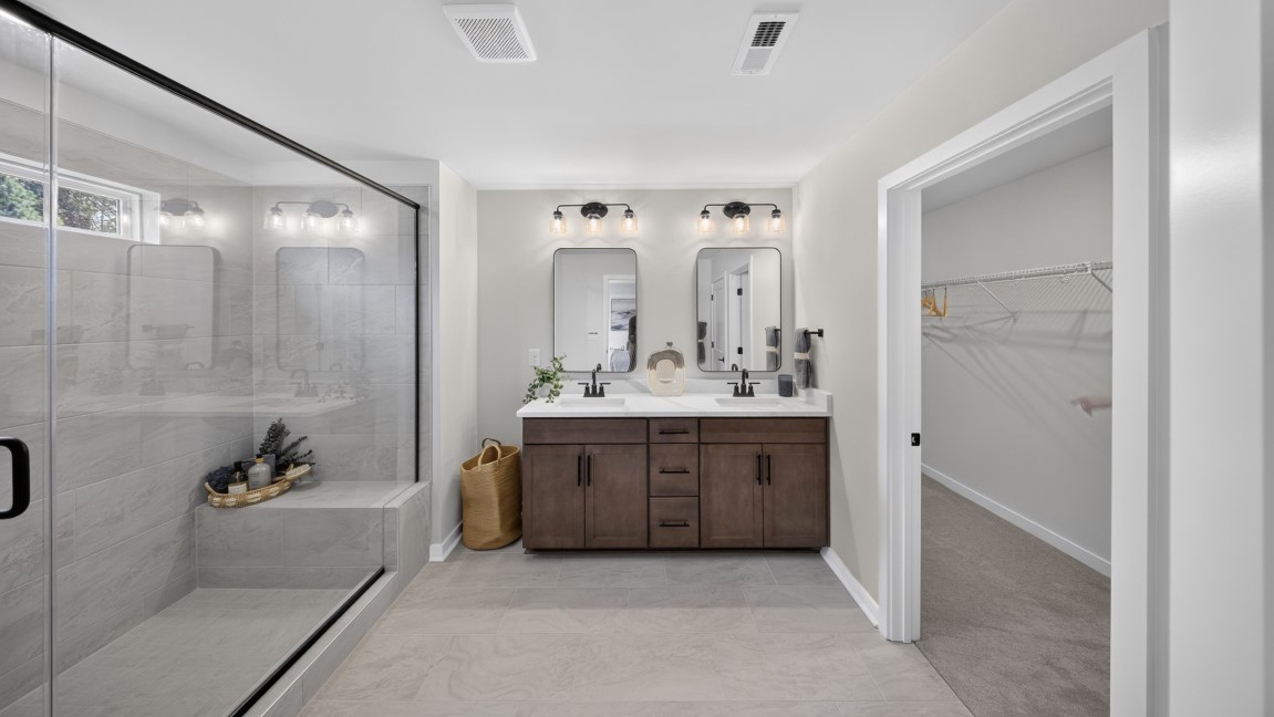 Primary bathroom with standing glass shower and double sinks