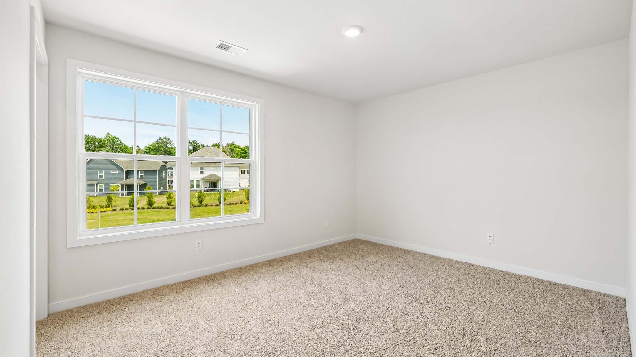 Carpeted bedroom with windows