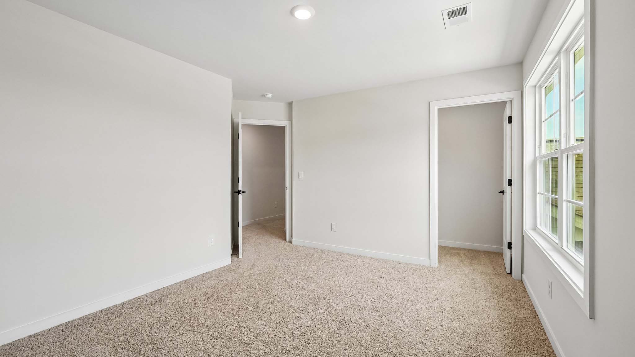 Carpeted bedroom with windows