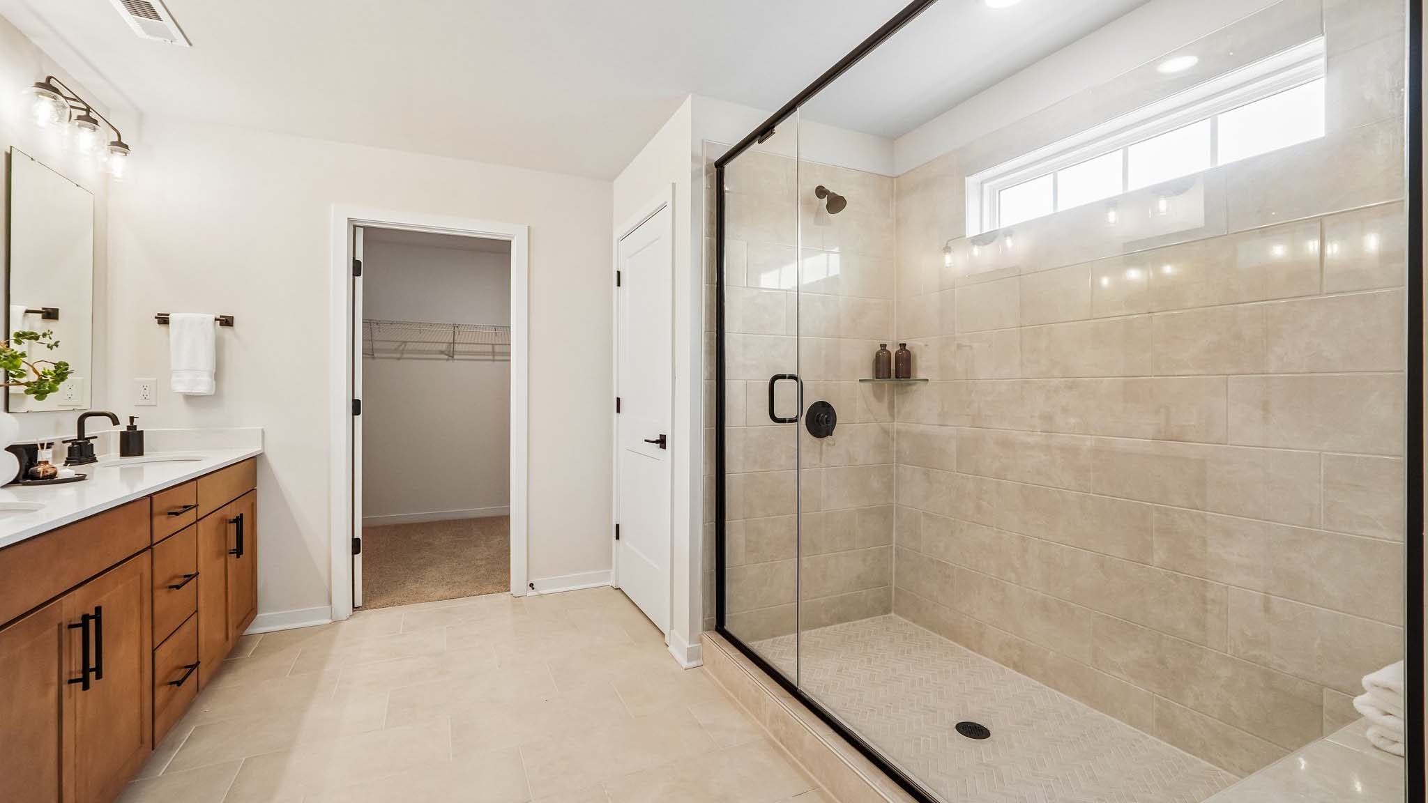 Primary bathroom with standing glass shower and double sinks