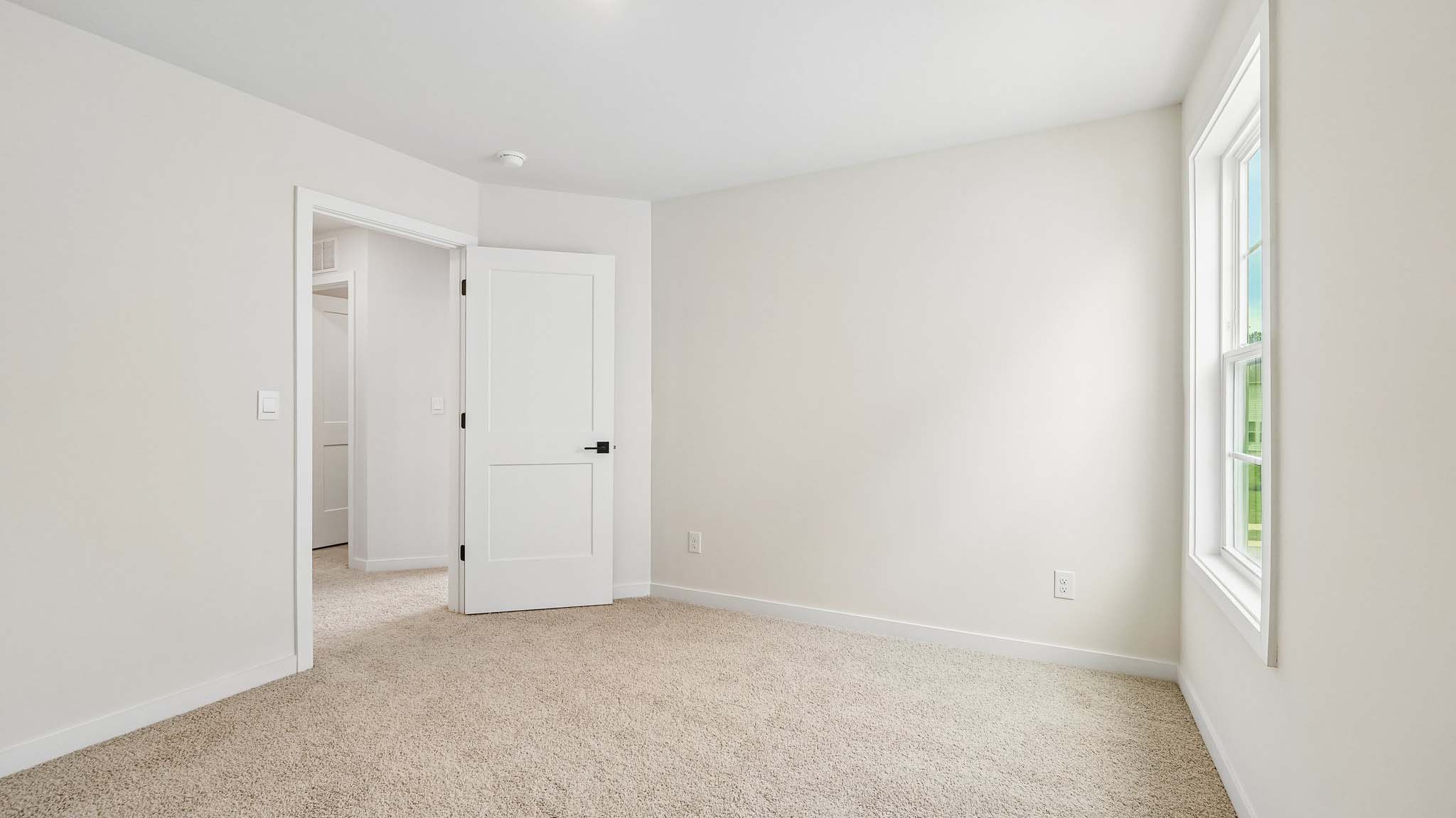 Carpeted bedroom with windows