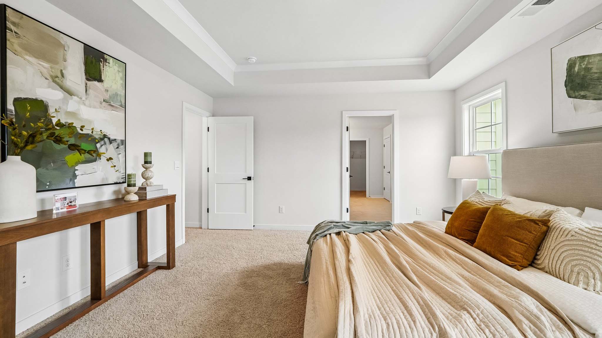 Primary carpeted bedroom with windows