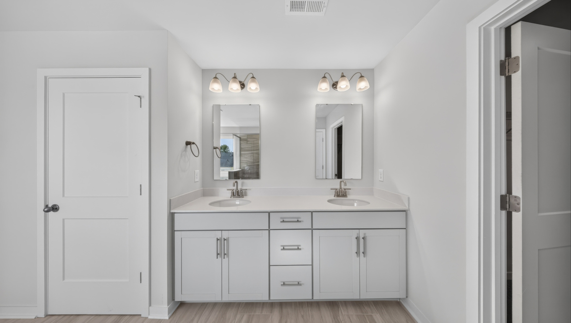 Primary bathroom with standing glass shower and double sinks