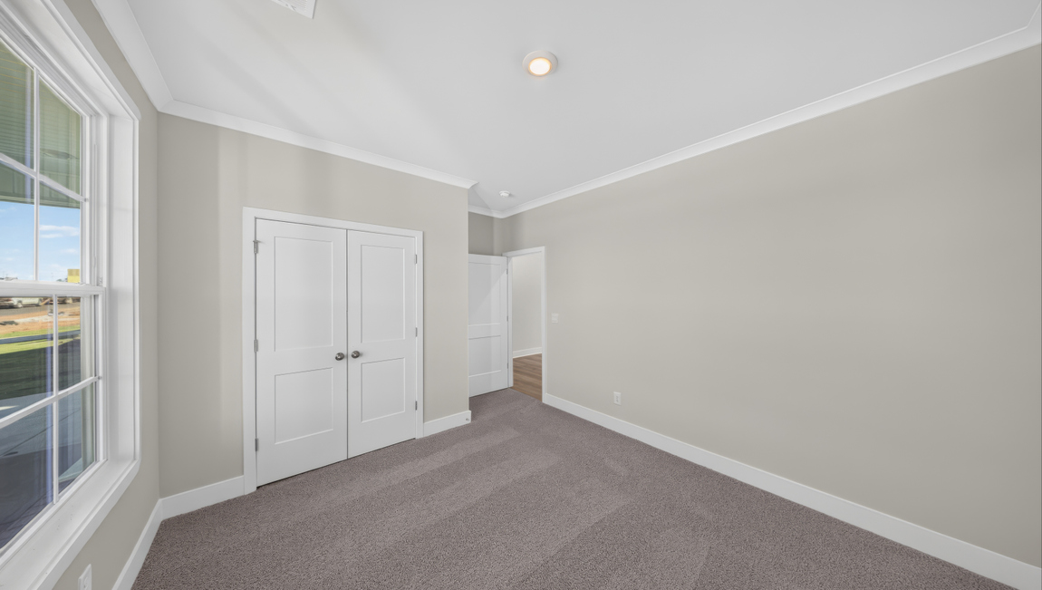 Carpeted bedroom with windows