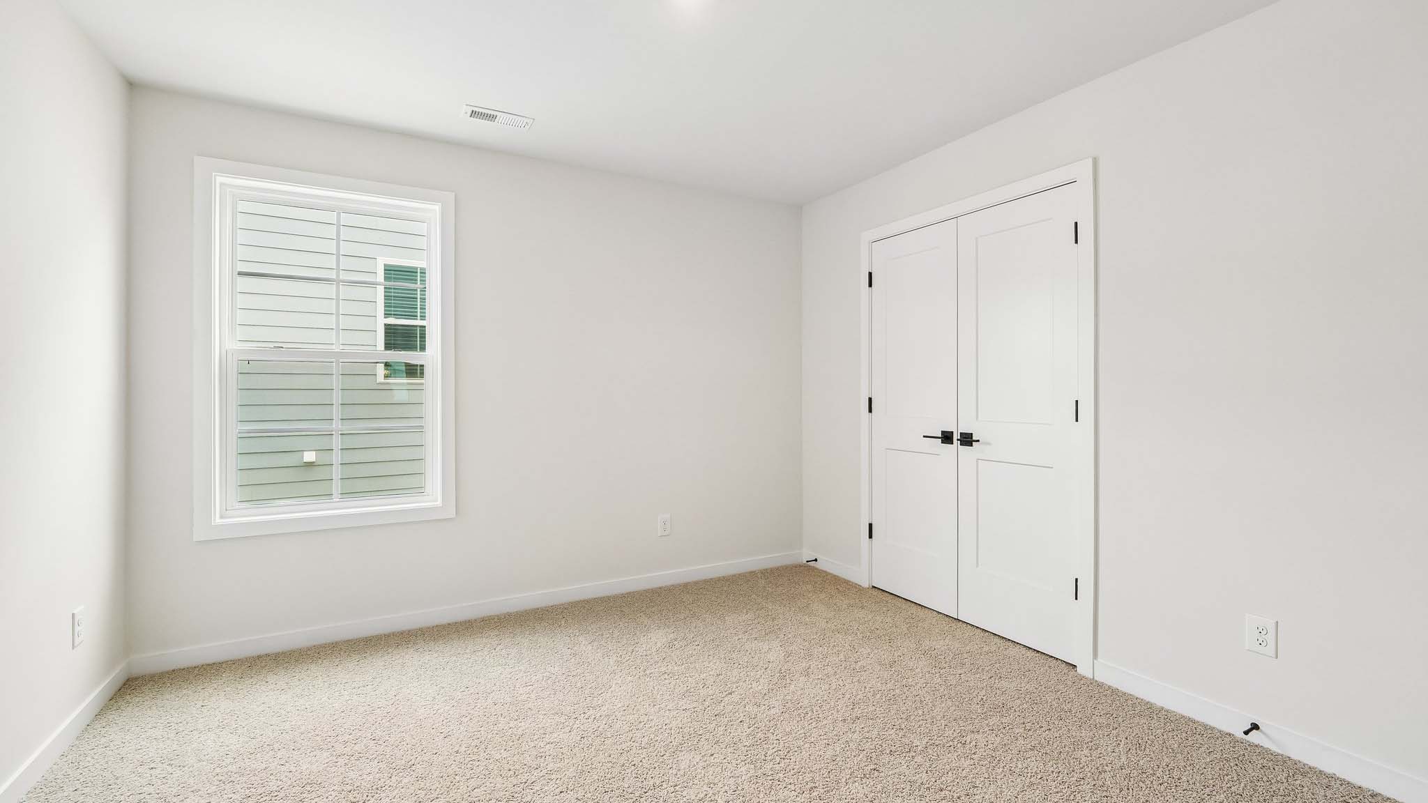 Carpeted bedroom with windows