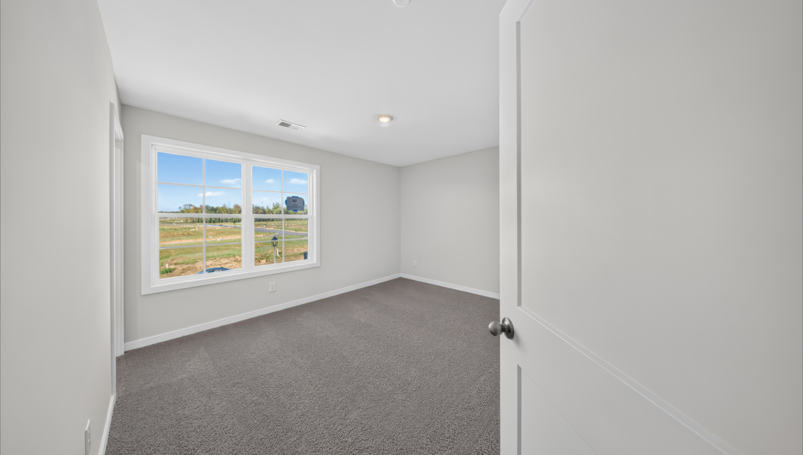 Carpeted bedroom with windows