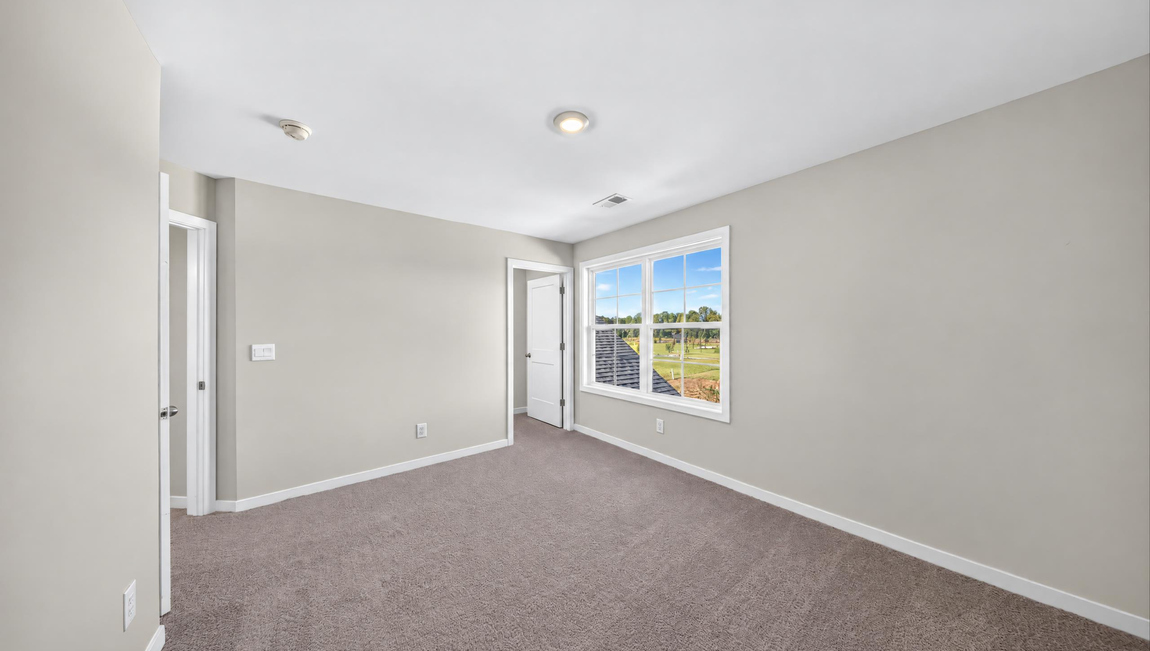 Carpeted bedroom with windows