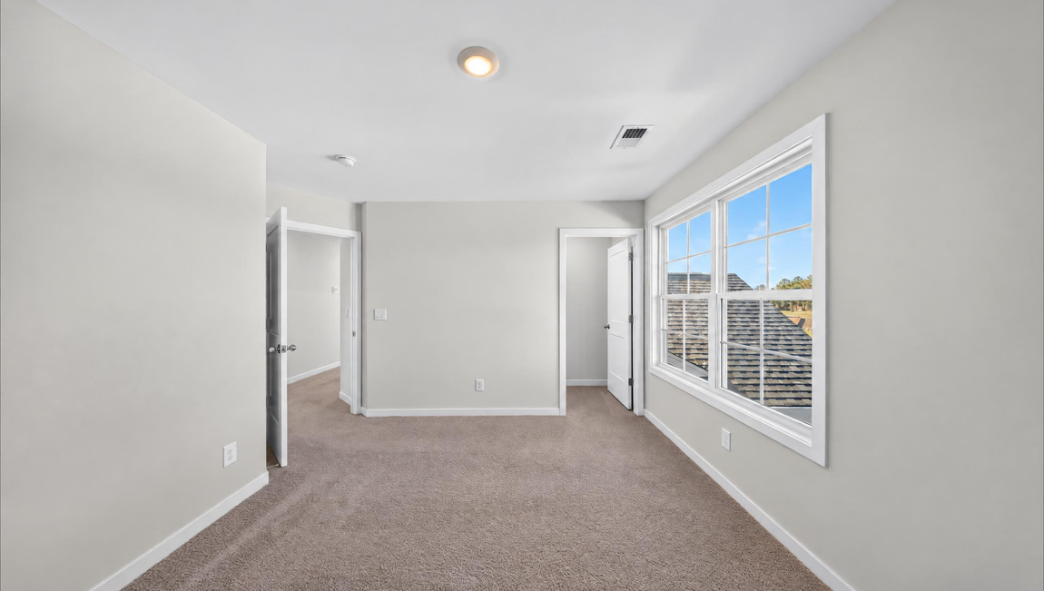 Carpeted bedroom with windows