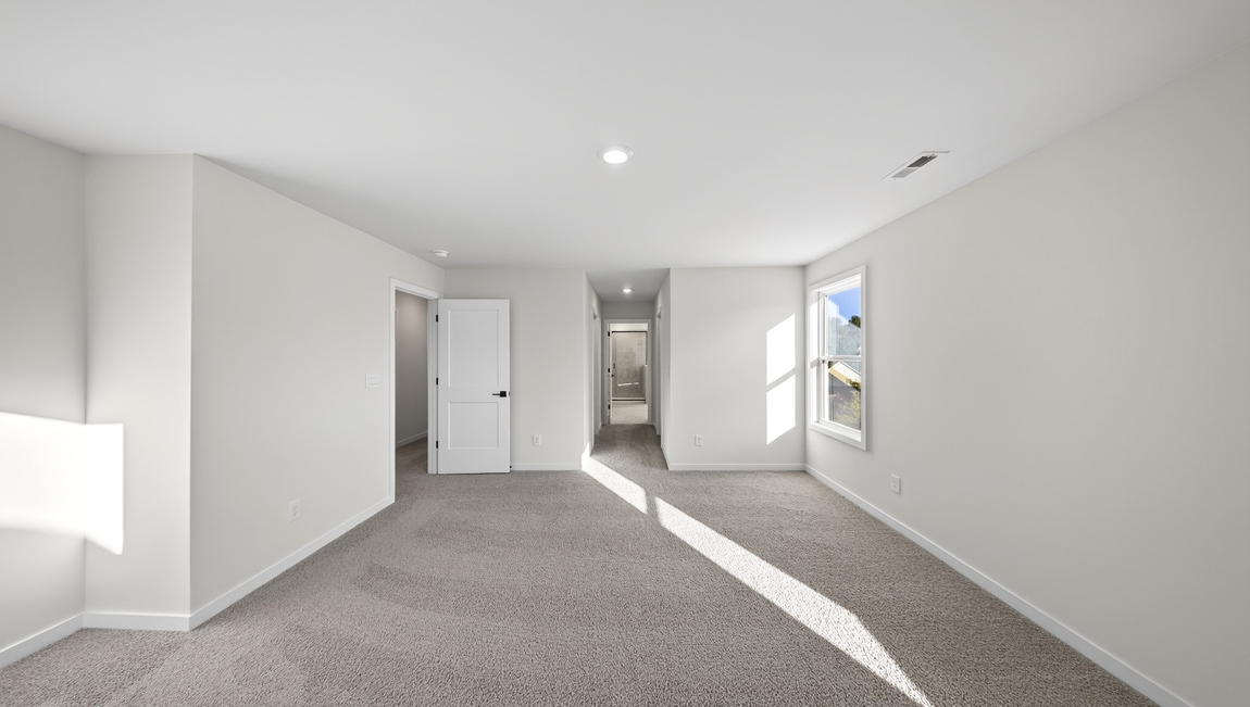 Primary carpeted bedroom with windows