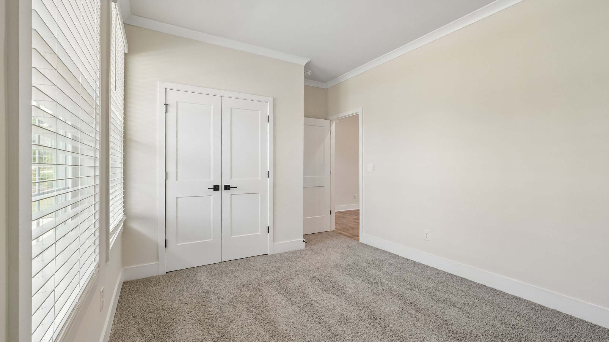 Carpeted bedroom with windows