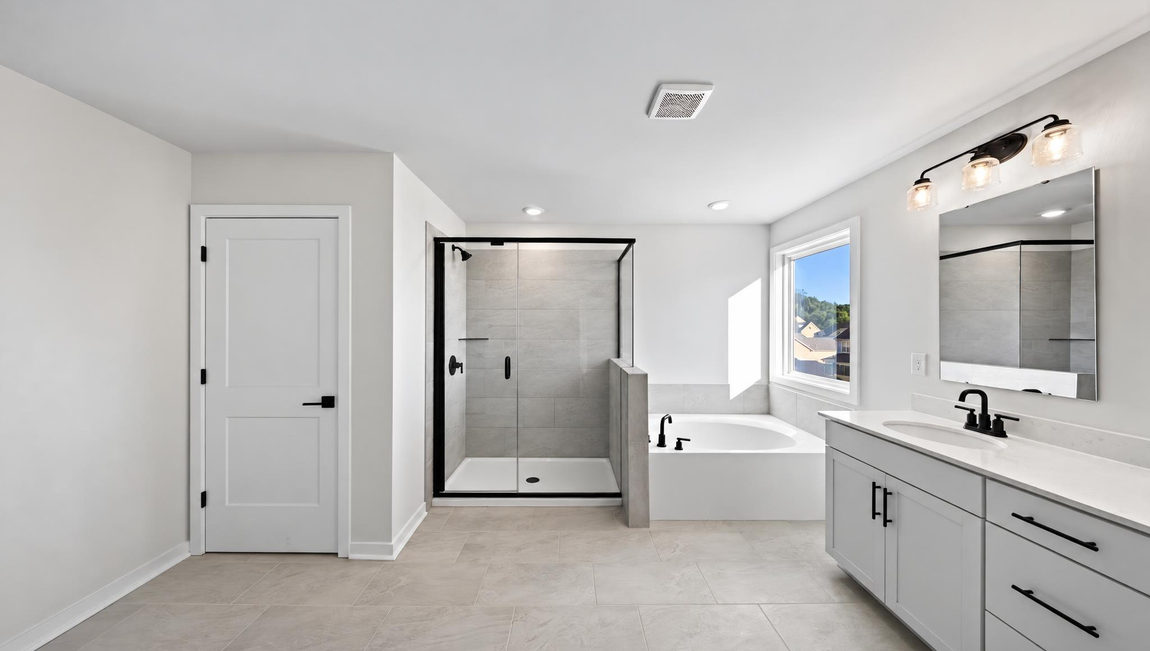 Primary bathroom with standing glass shower and double sinks