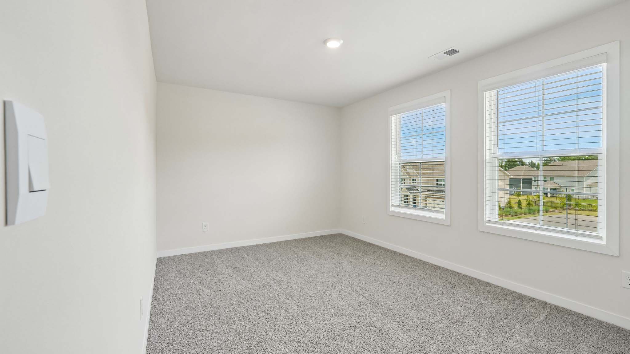 Carpeted bedroom with windows