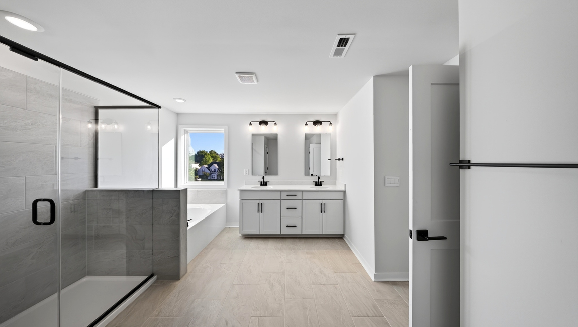 Primary bathroom with standing glass shower and double sinks