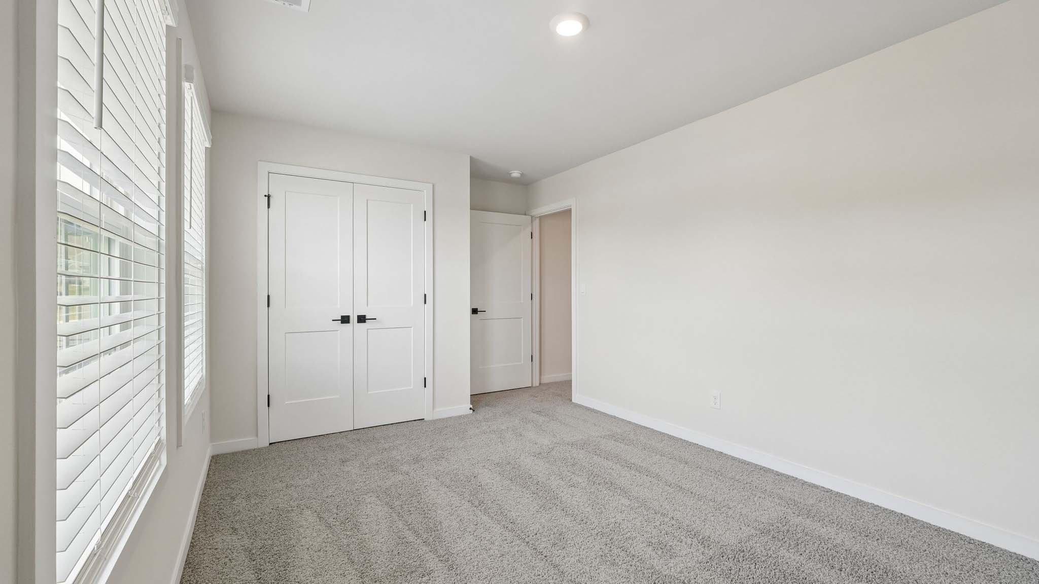 Carpeted bedroom with windows