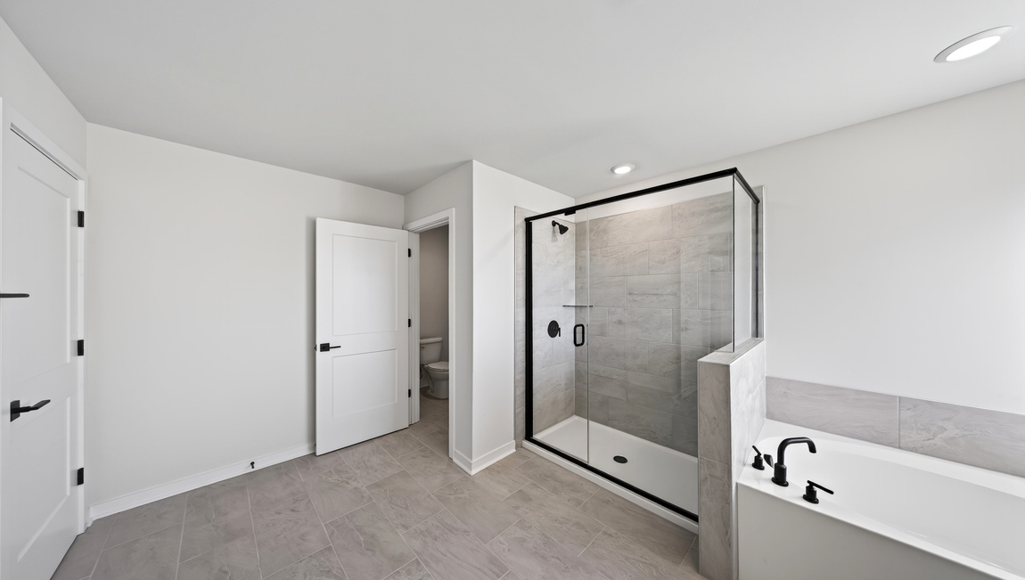 Primary bathroom with standing glass shower and double sinks