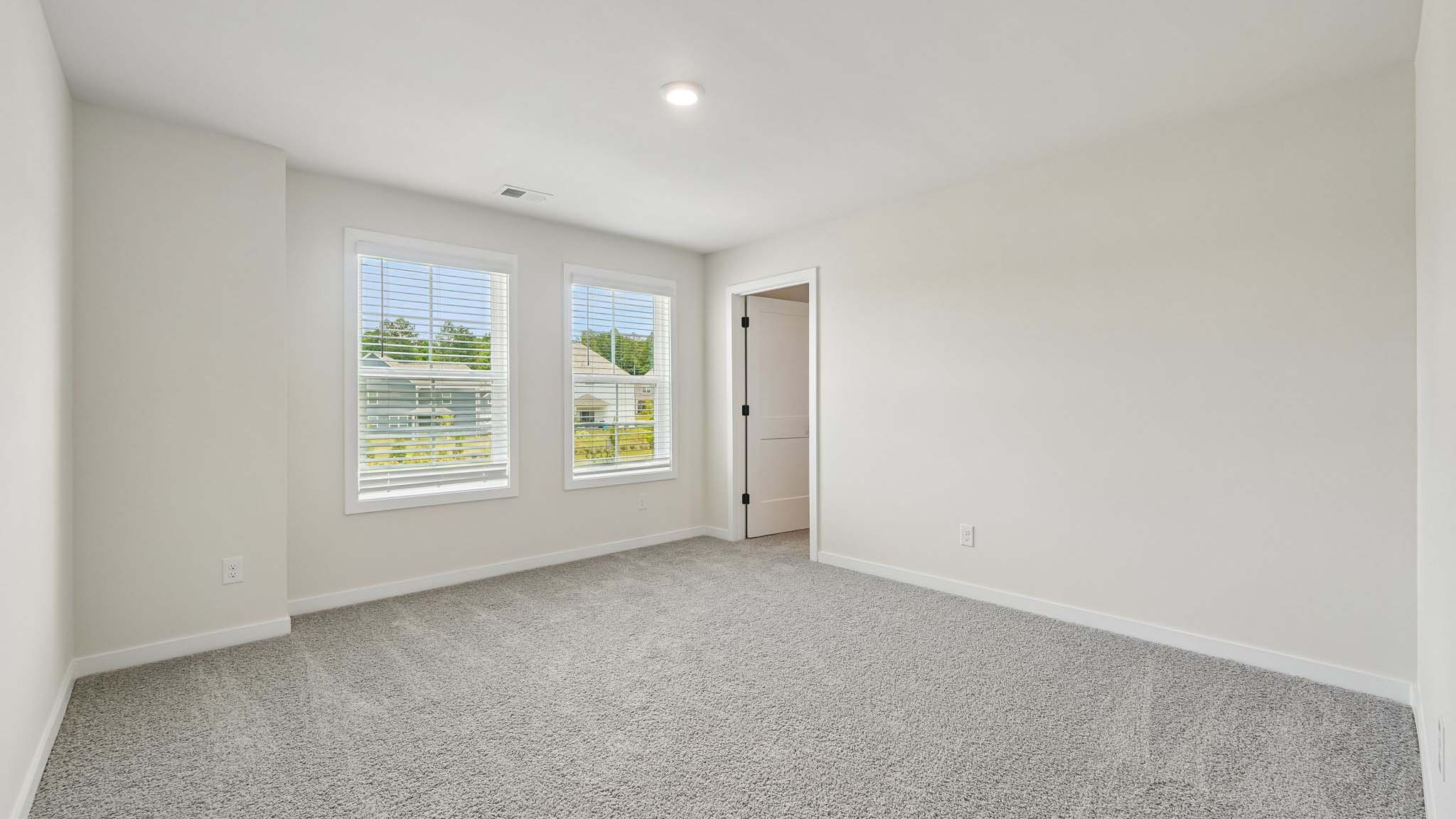 Carpeted bedroom with windows