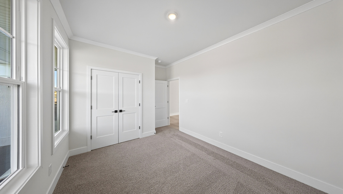 Carpeted bedroom with windows