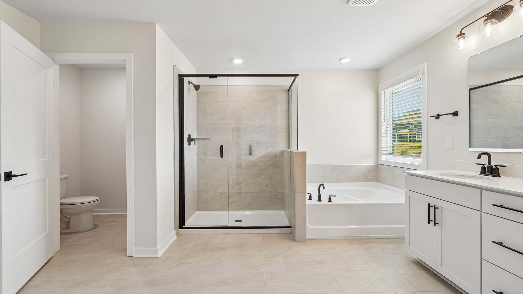 Primary bathroom with standing glass shower and double sinks