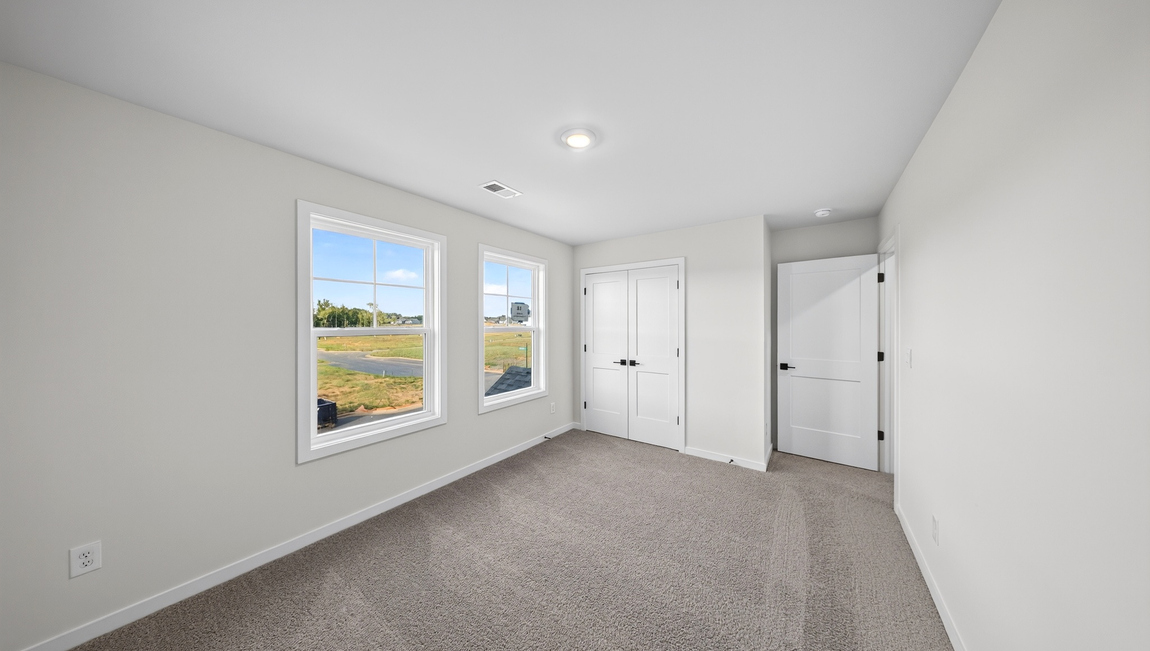 Carpeted bedroom with windows