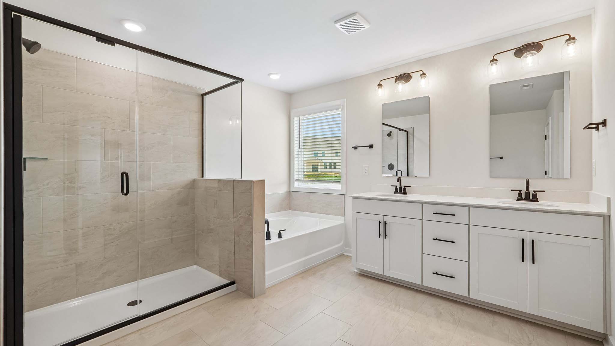 Primary bathroom with standing glass shower and double sinks