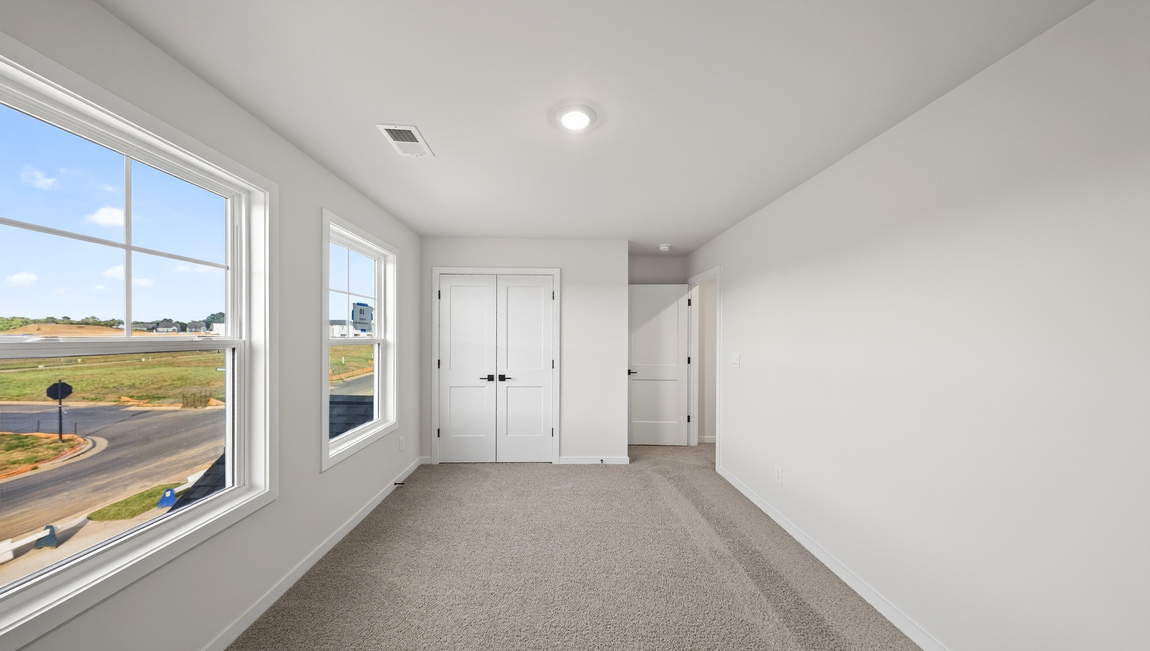 Carpeted bedroom with windows