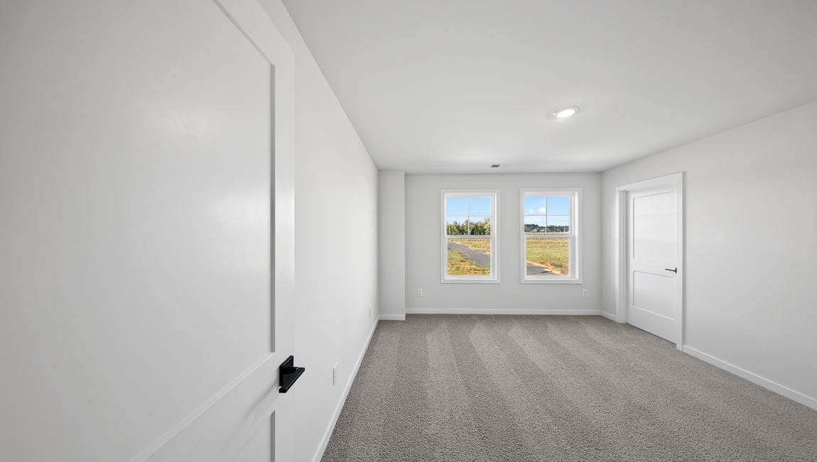 Carpeted bedroom with windows