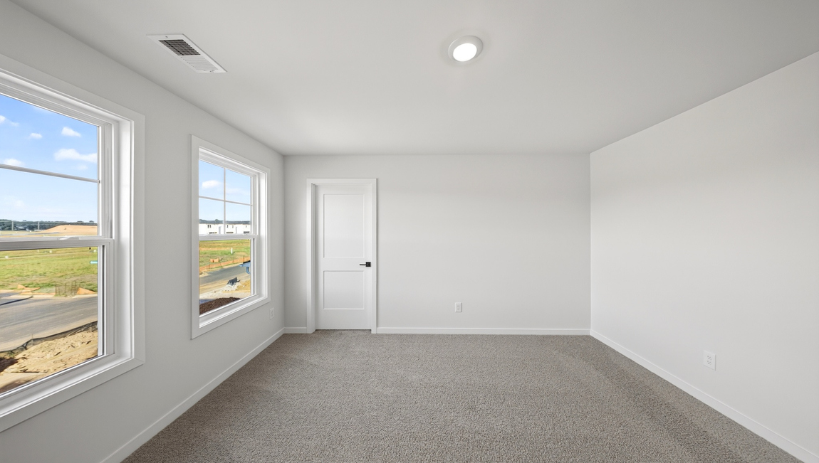 Carpeted bedroom with windows