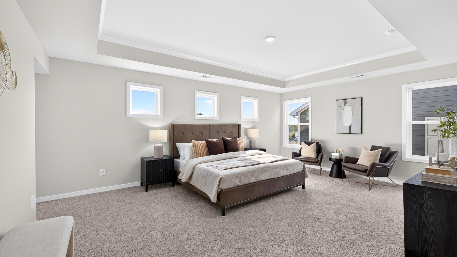 Primary carpeted bedroom with windows