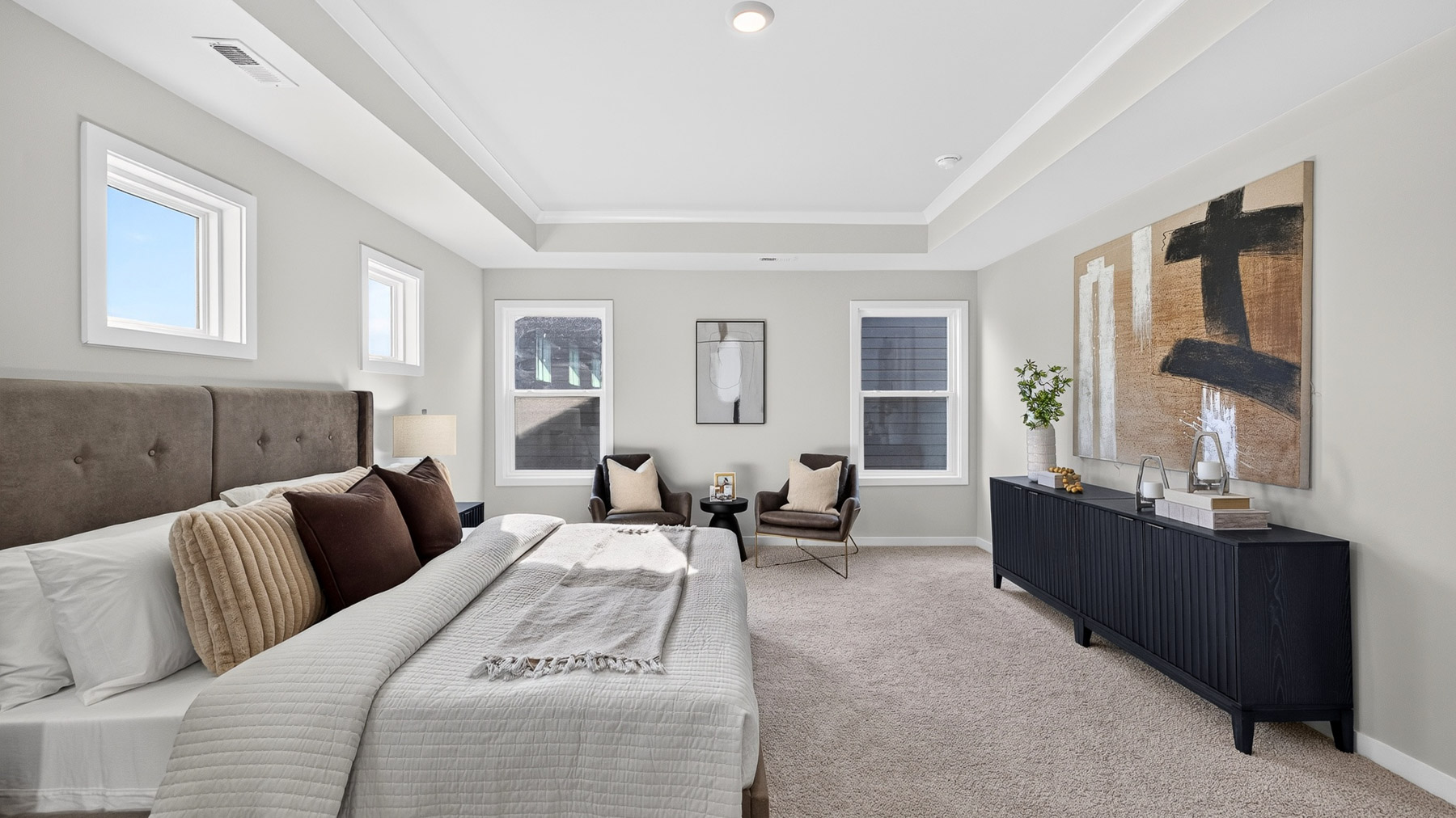 Primary carpeted bedroom with windows
