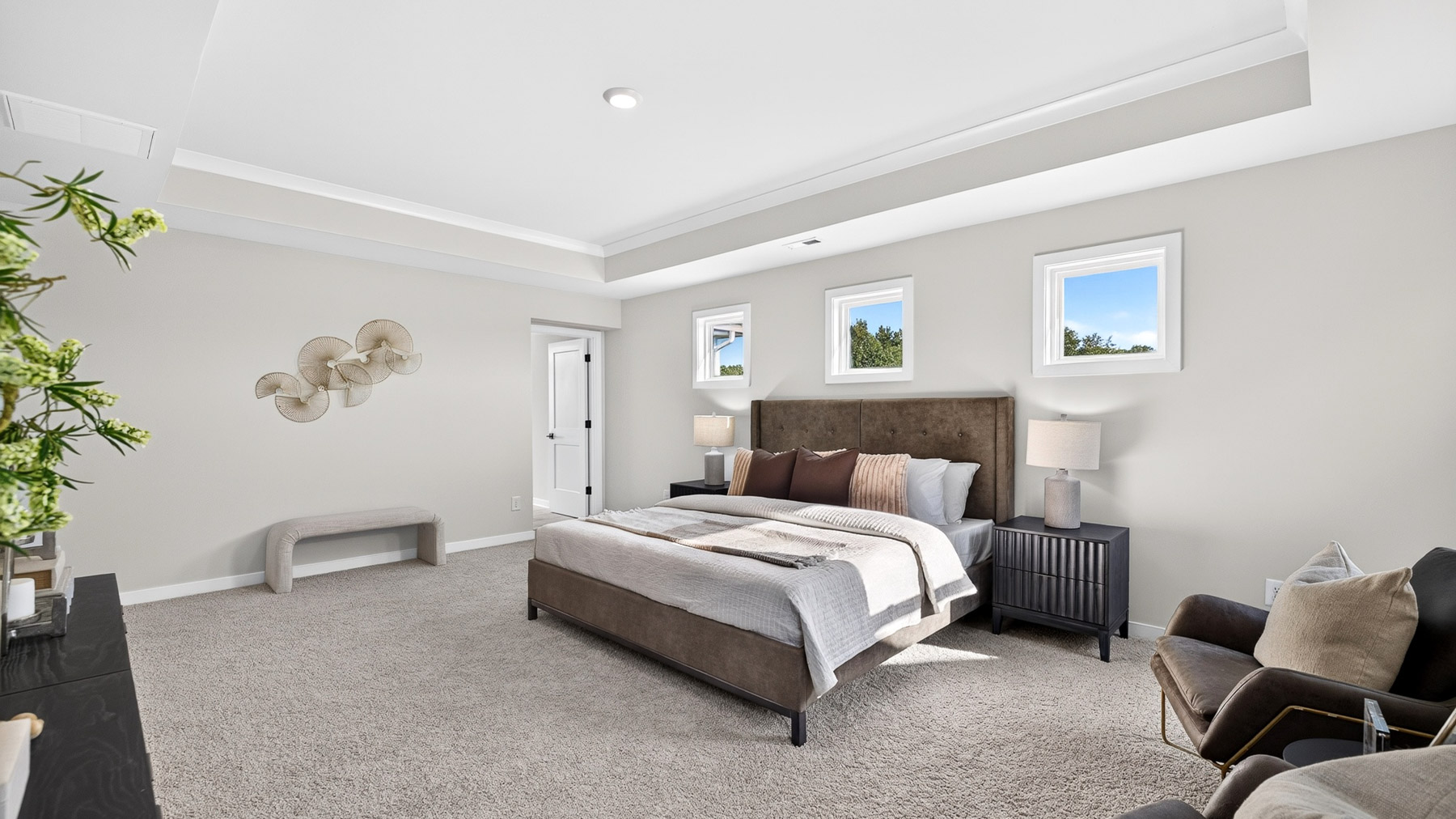 Primary carpeted bedroom with windows