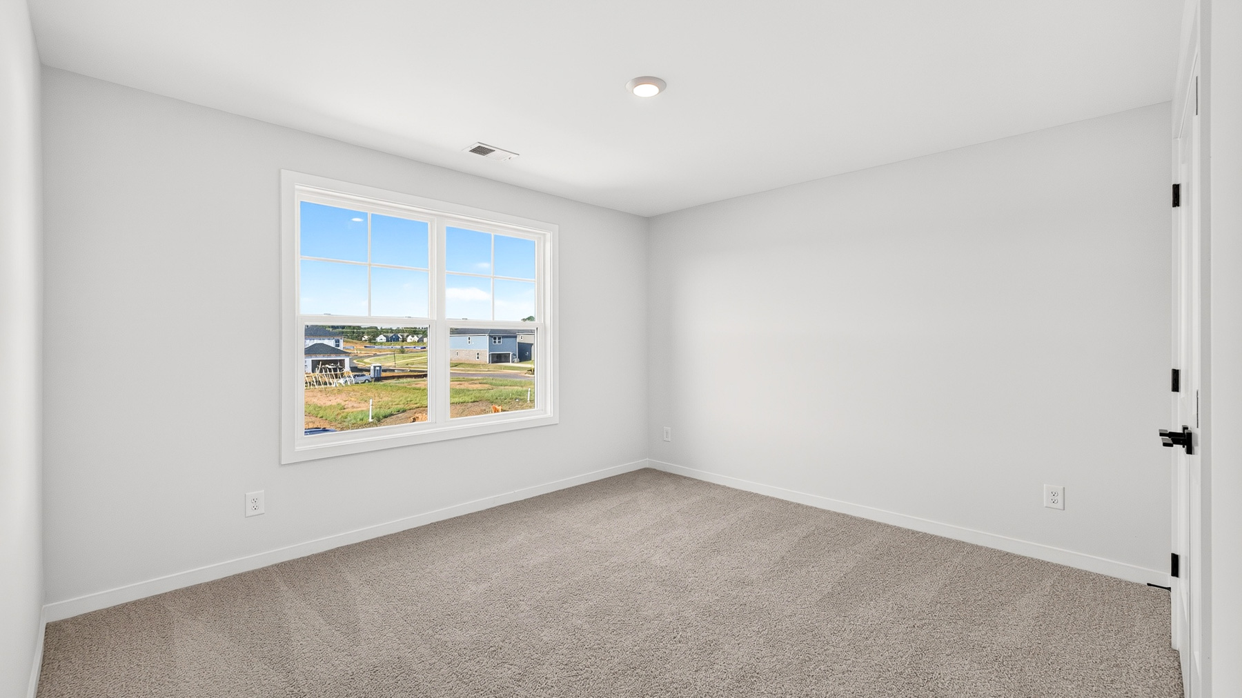 Carpeted bedroom with windows