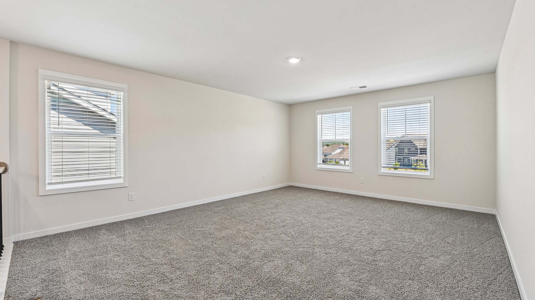 Upstairs carpeted loft with windows