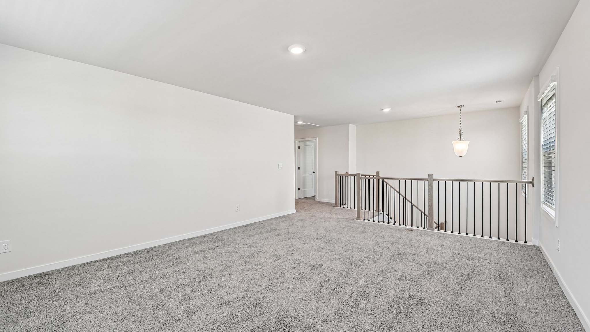 Upstairs carpeted loft with windows