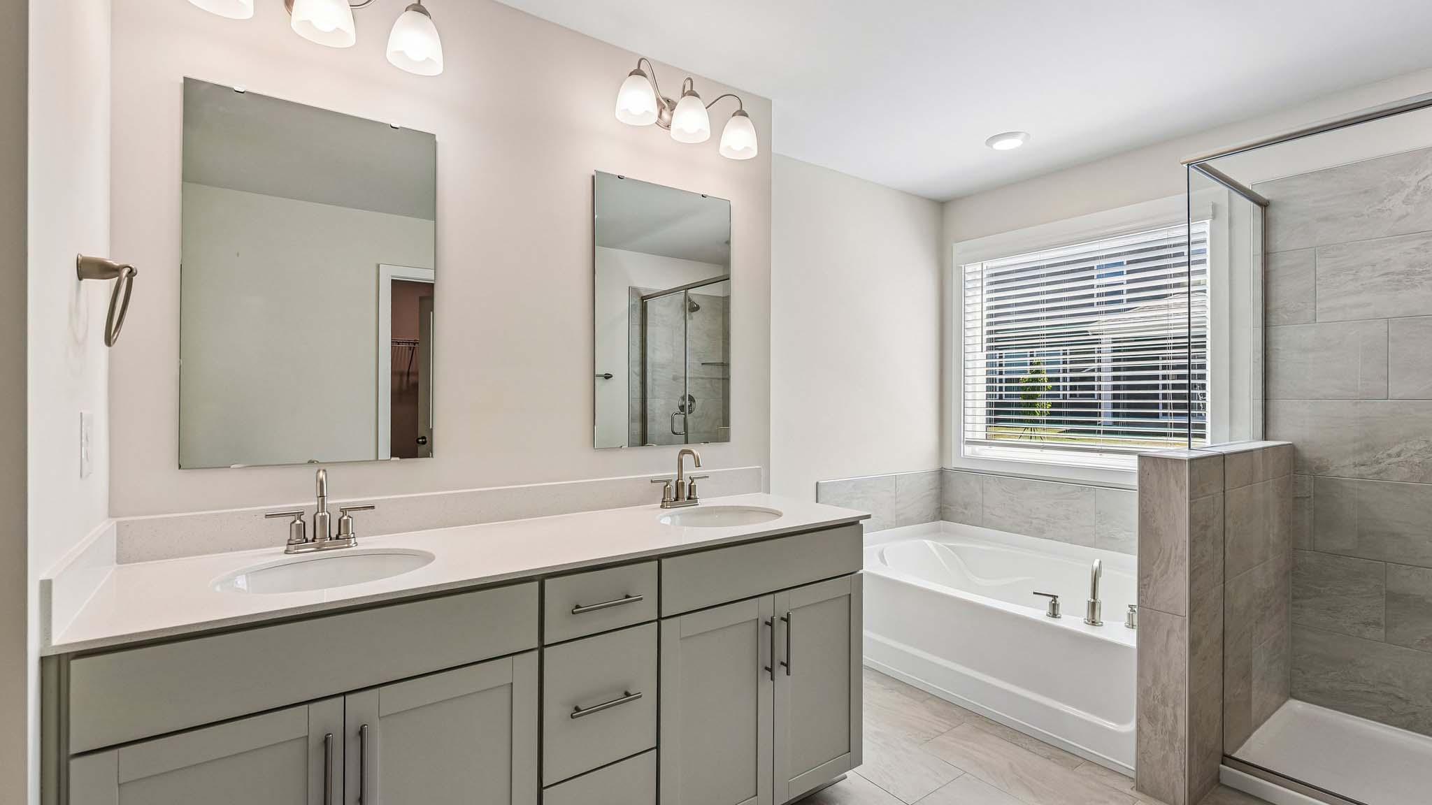 Primary bathroom with double sinks and standing glass shower