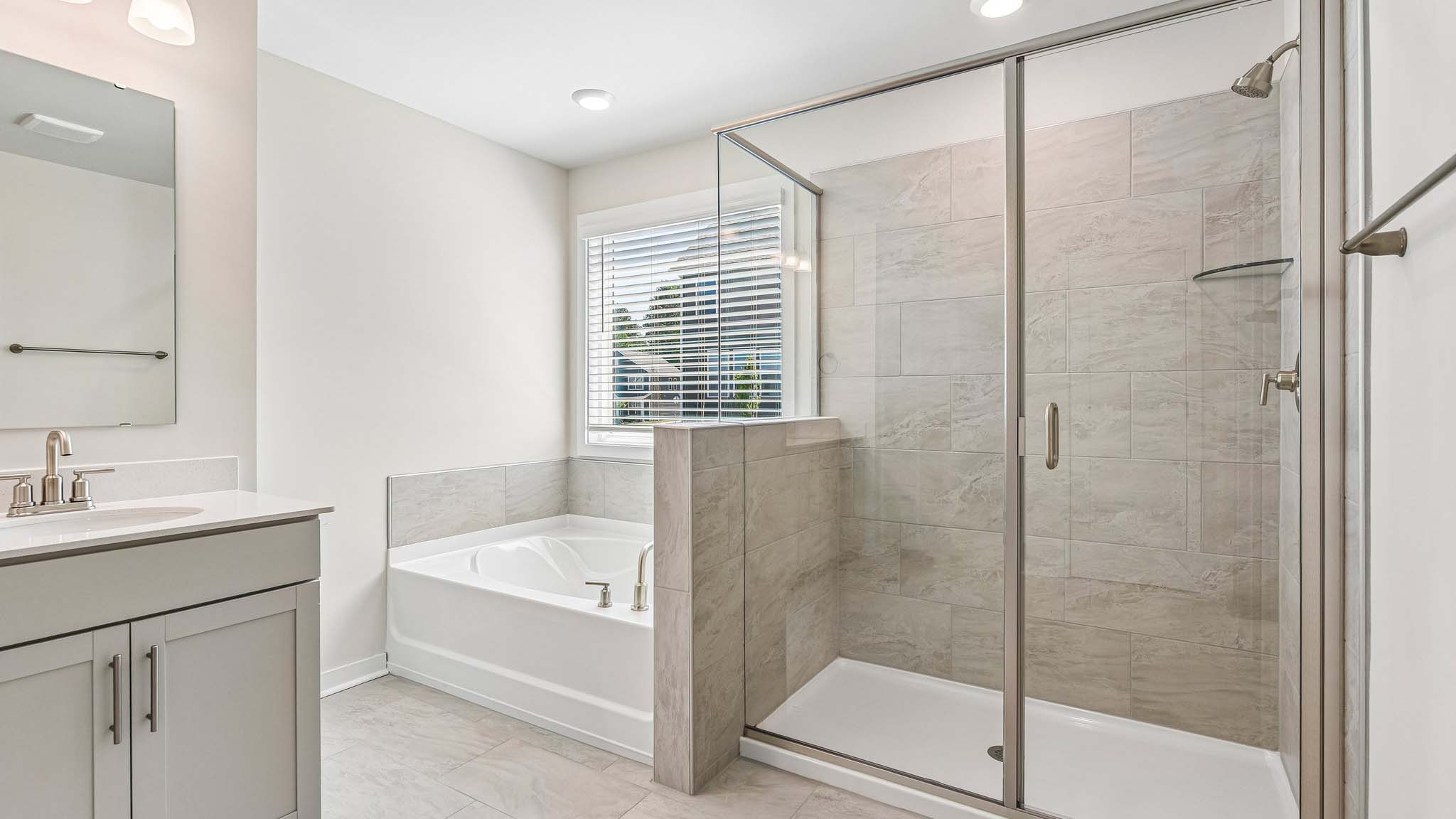 Primary bathroom with double sinks and standing glass shower
